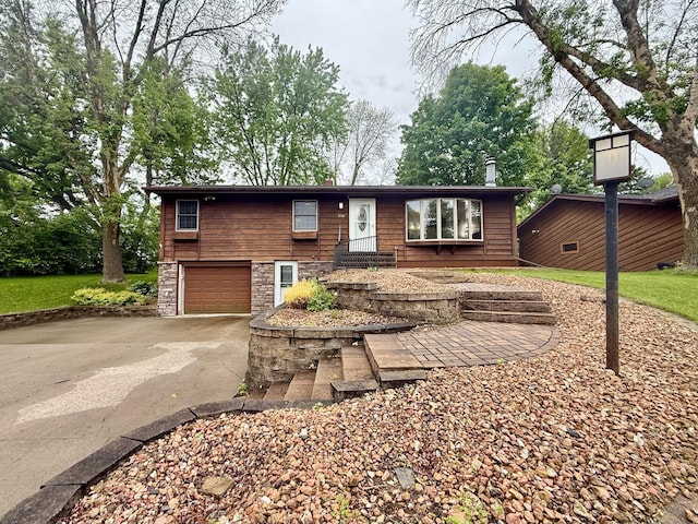 715 Crest Ln, Ellsworth, WI 54011 - view of front of house featuring driveway, a garage, and stone siding