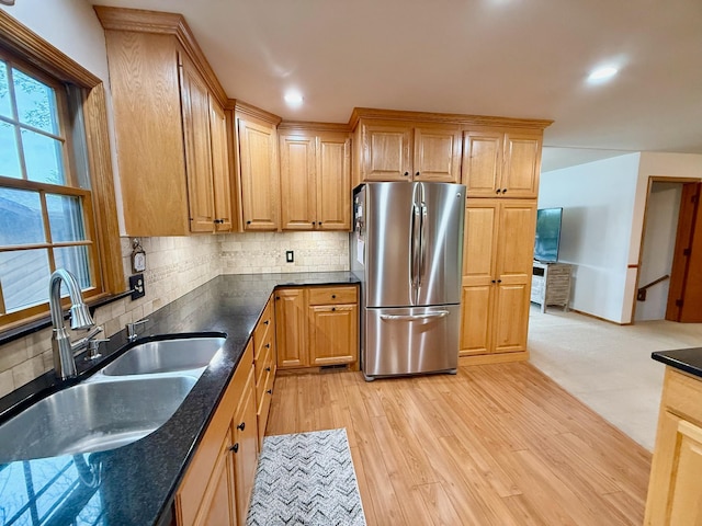 715 Crest Ln, Ellsworth, WI 54011 - kitchen with freestanding refrigerator, a sink, backsplash, light wood-style floors, and dark stone countertops