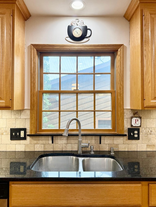 715 Crest Ln, Ellsworth, WI 54011 - kitchen featuring a sink, backsplash, dark stone countertops, and brown cabinets