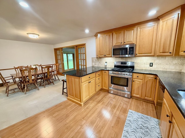 715 Crest Ln, Ellsworth, WI 54011 - kitchen with appliances with stainless steel finishes, a peninsula, backsplash, light wood-style flooring, and recessed lighting