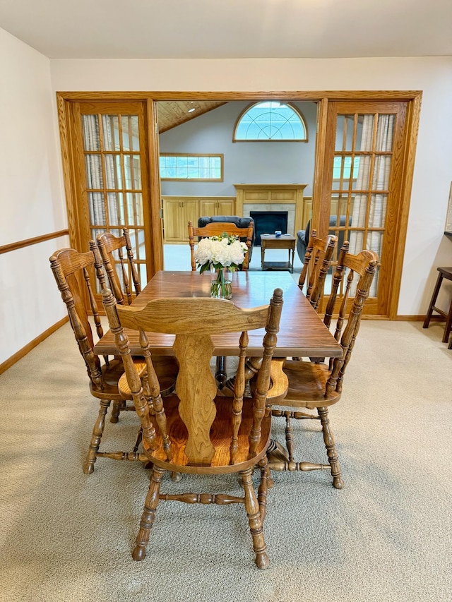 715 Crest Ln, Ellsworth, WI 54011 - carpeted dining space featuring baseboards, a fireplace, and lofted ceiling