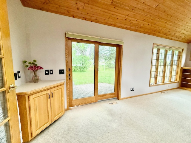 715 Crest Ln, Ellsworth, WI 54011 - doorway to outside featuring light carpet, plenty of natural light, wood ceiling, and baseboards