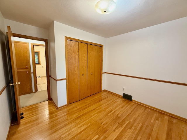 715 Crest Ln, Ellsworth, WI 54011 - unfurnished bedroom featuring light wood-type flooring, a closet, and baseboards