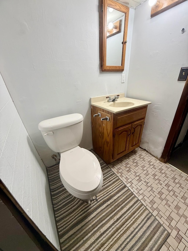 715 Crest Ln, Ellsworth, WI 54011 - bathroom featuring toilet, vanity, and brick patterned flooring