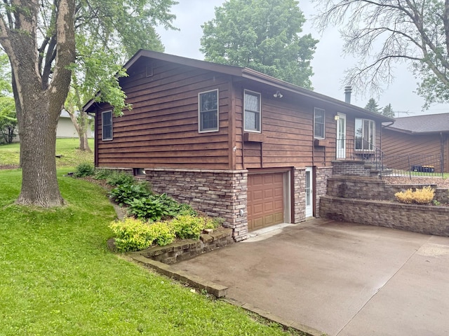 715 Crest Ln, Ellsworth, WI 54011 - view of side of home with an attached garage, stone siding, a yard, and driveway