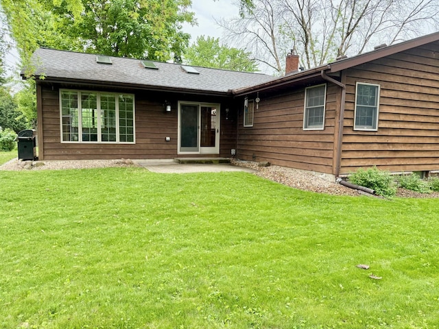 715 Crest Ln, Ellsworth, WI 54011 - back of property with a chimney, a lawn, and a patio area