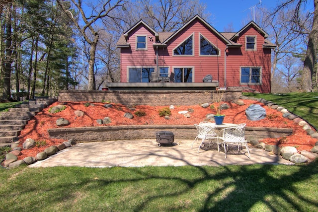 rear view of house with a yard, a patio area, a fire pit, and stairway