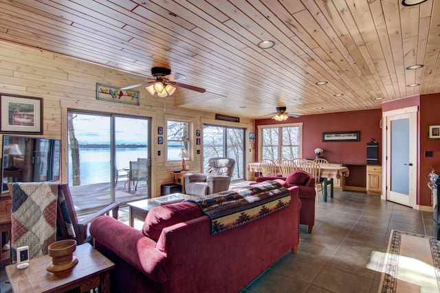 living room with a water view, baseboards, a ceiling fan, and wood ceiling