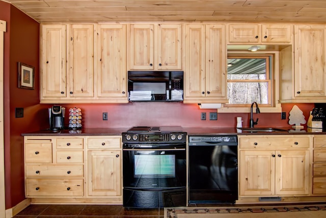 kitchen featuring black appliances, dark countertops, light brown cabinets, and a sink