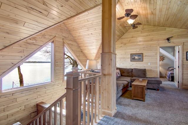 interior space featuring a water view, wooden ceiling, wood walls, and lofted ceiling