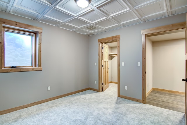 unfurnished bedroom with a spacious closet, carpet flooring, baseboards, and a closet