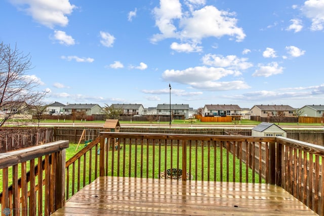 wooden deck with a yard, a residential view, and a fenced backyard
