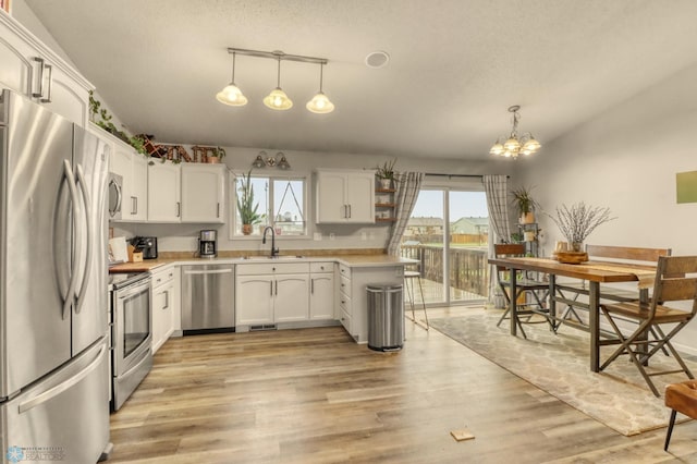 kitchen with light countertops, white cabinetry, appliances with stainless steel finishes, and a sink