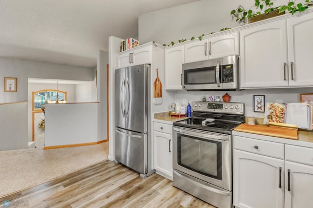 kitchen featuring light countertops, stainless steel appliances, and white cabinetry