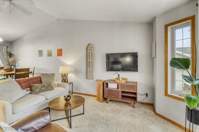 carpeted living room featuring baseboards, ceiling fan, and vaulted ceiling