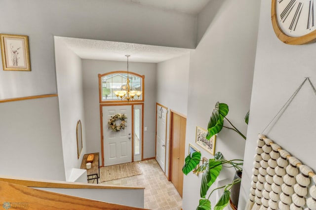 foyer entrance featuring an inviting chandelier and a high ceiling