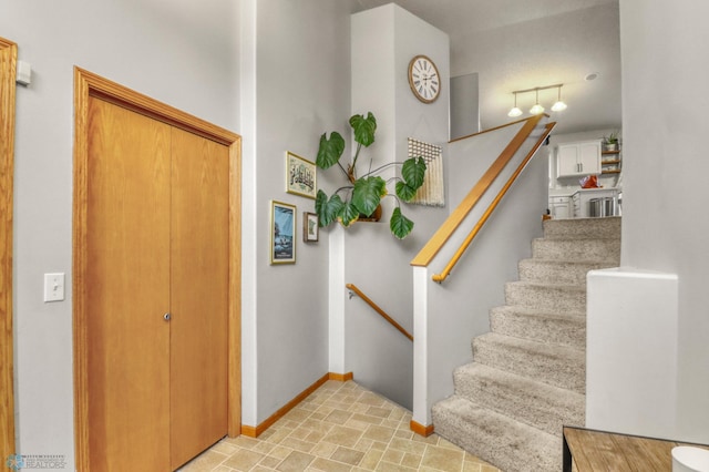 staircase with baseboards and stone finish floor