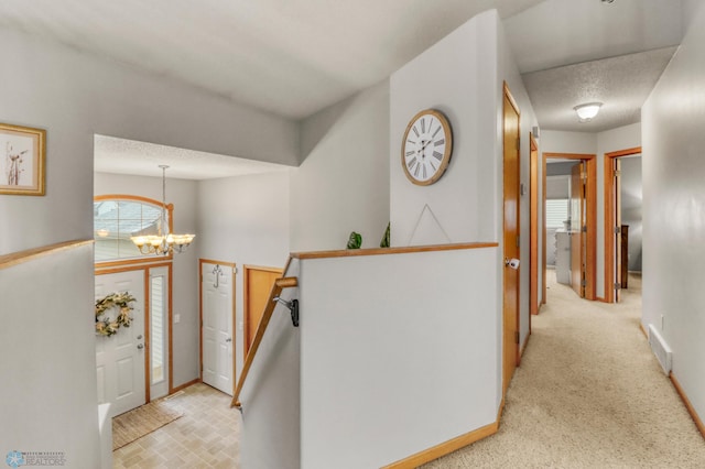 foyer entrance with light colored carpet, baseboards, a chandelier, and visible vents
