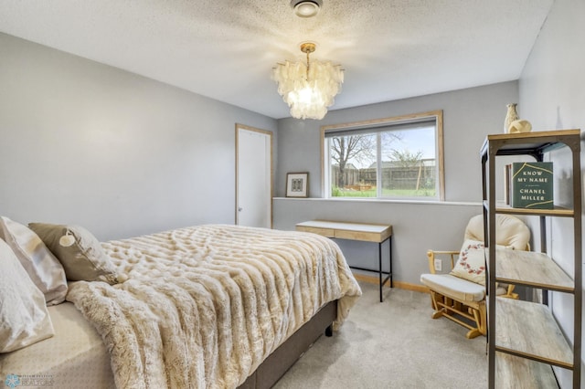 carpeted bedroom with baseboards and a chandelier