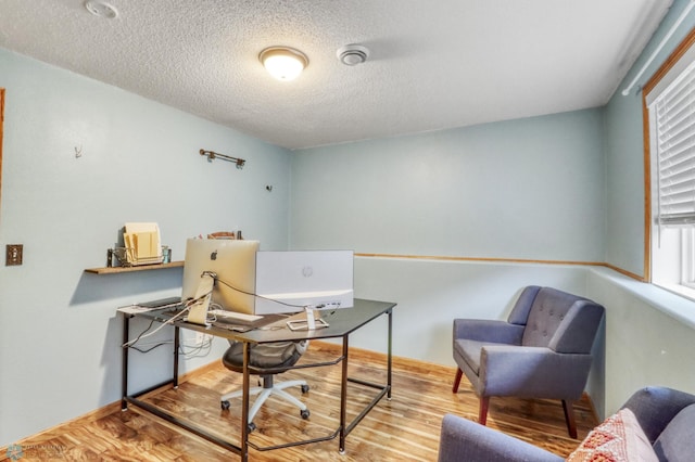 office area with a textured ceiling and wood finished floors