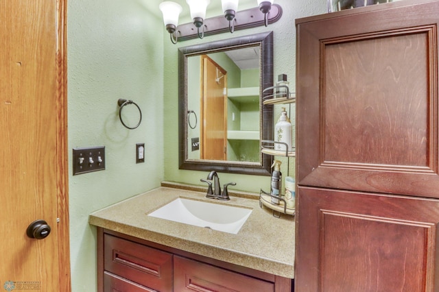 bathroom with a textured wall and vanity