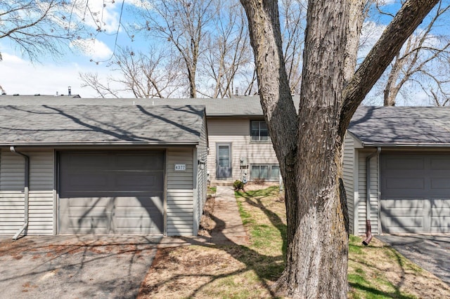 view of front of home featuring a shingled roof and aphalt driveway