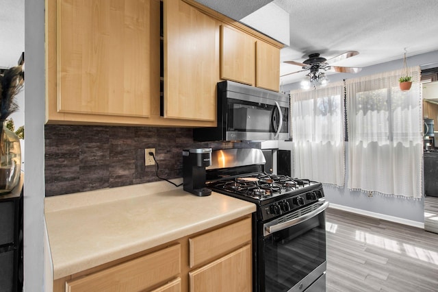kitchen featuring decorative backsplash, stainless steel appliances, light brown cabinets, ceiling fan, and light countertops