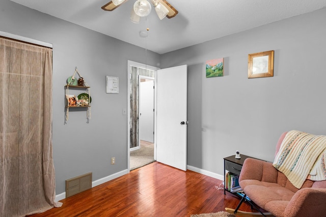 sitting room featuring wood finished floors, visible vents, ceiling fan, and baseboards