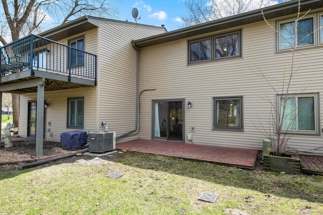 back of house with a wooden deck, a yard, and central AC