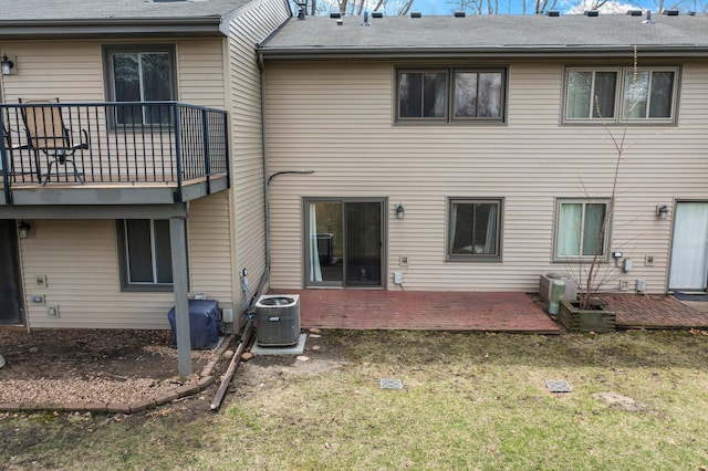 rear view of property featuring a patio, cooling unit, a balcony, and a lawn