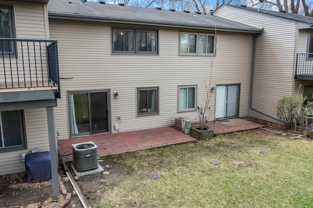 rear view of house featuring central AC and a yard