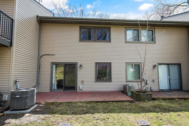 back of property featuring central AC, a deck, and a yard