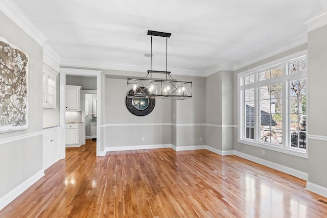 unfurnished dining area with baseboards, a chandelier, a healthy amount of sunlight, and light wood finished floors