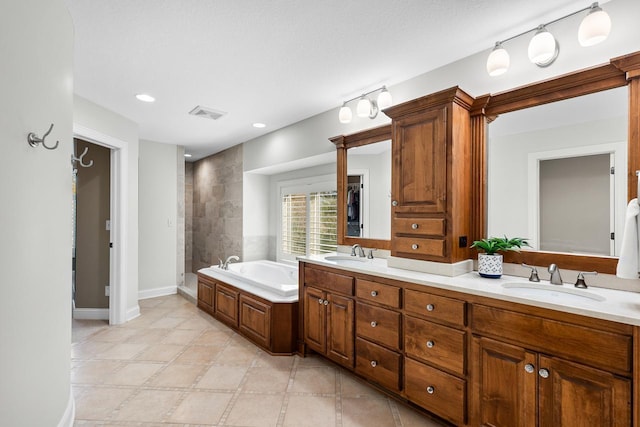 full bath with a sink, a garden tub, double vanity, and visible vents