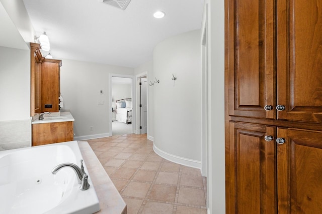 full bath featuring visible vents, vanity, baseboards, a jetted tub, and recessed lighting