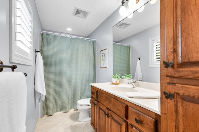 bathroom featuring visible vents, tile patterned floors, toilet, and vanity