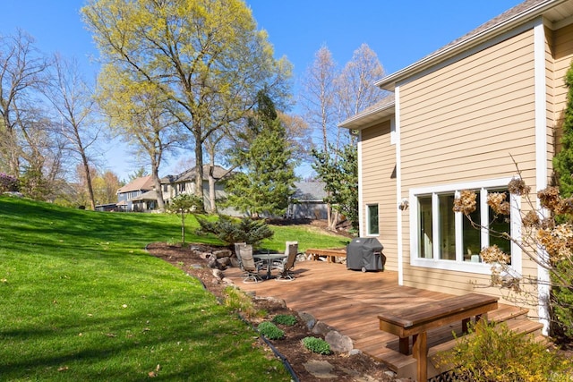 wooden deck featuring a lawn and a grill