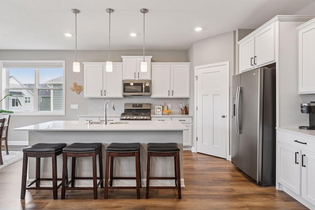 7393 Emily Cir, Lino Lakes, MN 55038 - kitchen with a sink, stainless steel appliances, a kitchen breakfast bar, white cabinetry, and light countertops