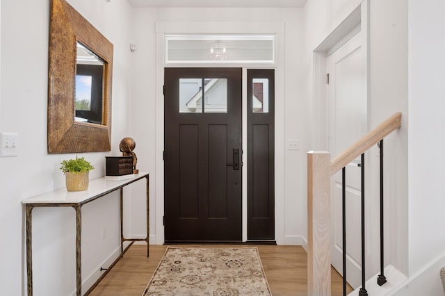 entrance foyer featuring light wood-type flooring, baseboards, and plenty of natural light
