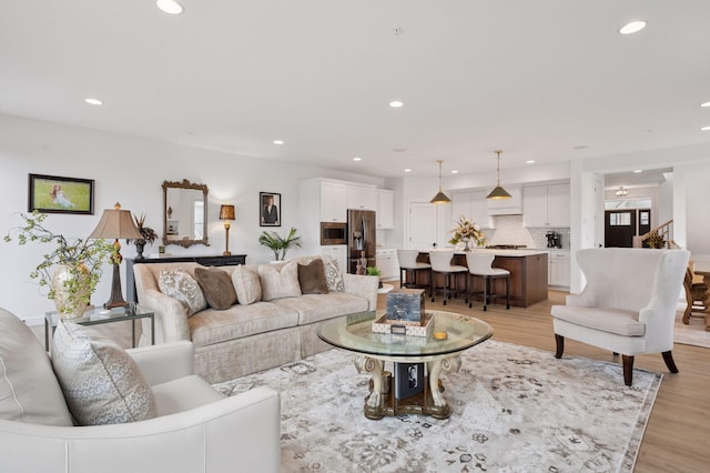 living area with light wood-type flooring and recessed lighting