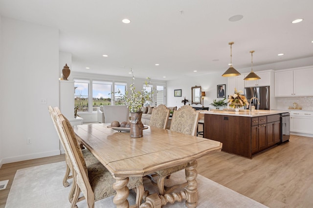 dining space featuring light wood-style floors, baseboards, recessed lighting, and visible vents