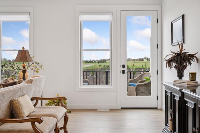 entryway featuring light wood-style floors, baseboards, and visible vents