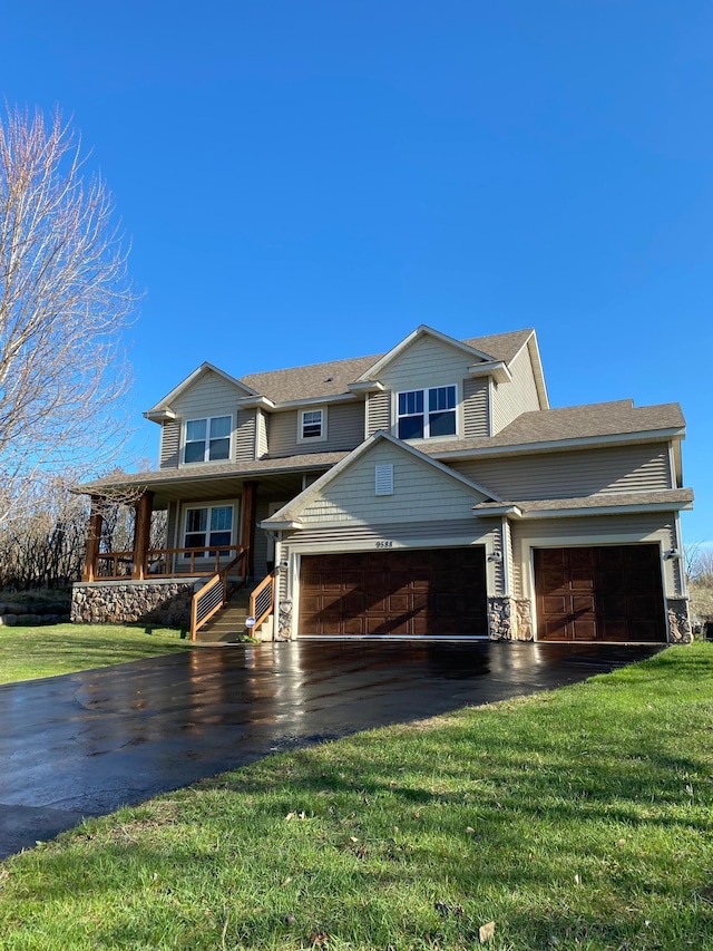 view of front facade with a garage, a porch, driveway, and a front lawn
