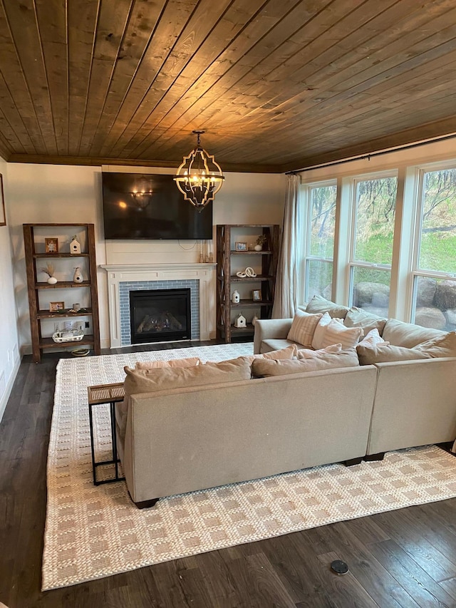 living area with a tiled fireplace, wood finished floors, a notable chandelier, and wooden ceiling
