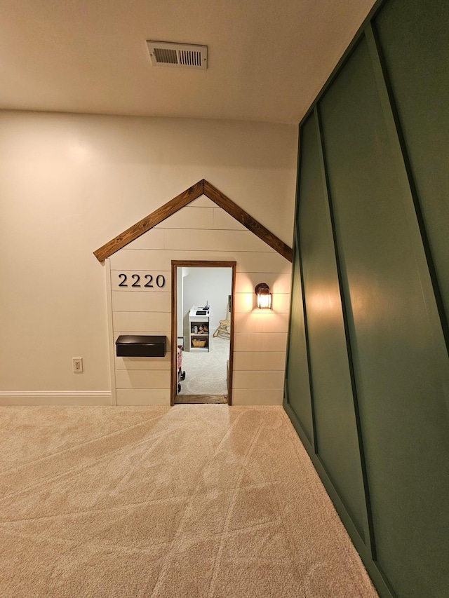 hallway with visible vents, carpet, and baseboards