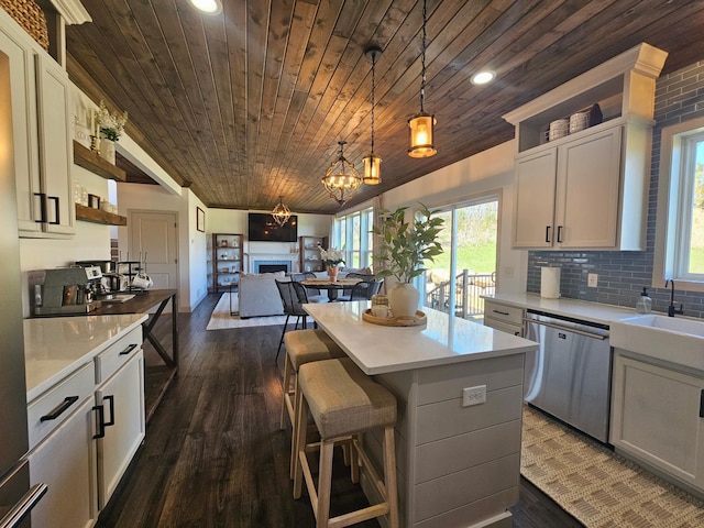 kitchen with light countertops, dark wood finished floors, dishwasher, and wooden ceiling