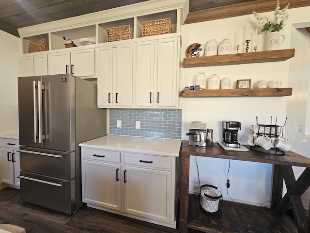 kitchen with dark wood-style flooring, open shelves, light countertops, freestanding refrigerator, and backsplash