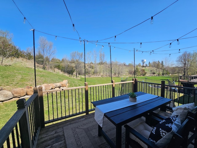 wooden deck featuring outdoor dining space and a yard