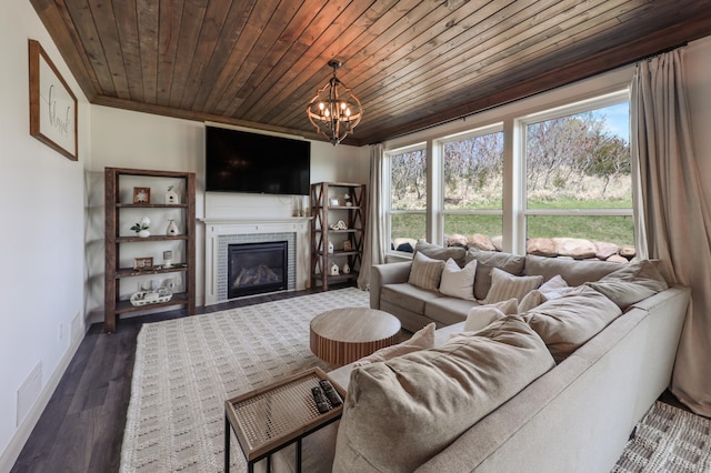 living area featuring visible vents, a glass covered fireplace, a chandelier, and a healthy amount of sunlight