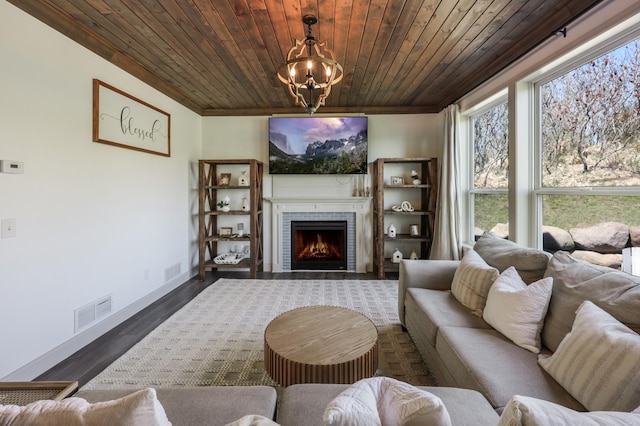 living room featuring visible vents, wood ceiling, a notable chandelier, and a fireplace